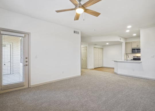 an empty living room with a ceiling fan and a kitchen at The Legends at Eagle Mountain Lake, Fort Worth, TX