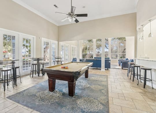 a game room with a pool table and a bunch of chairs