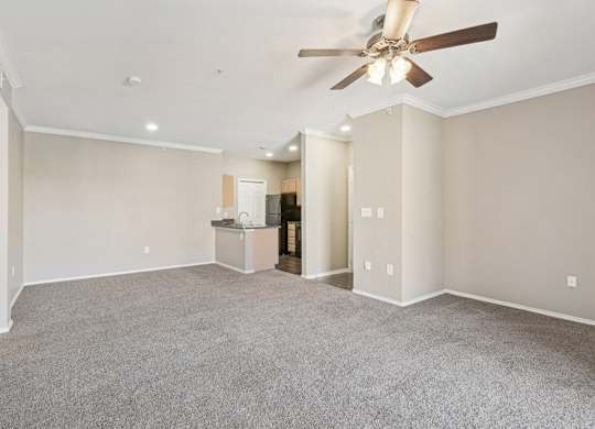 the living room and kitchen of a new home with a ceiling fan