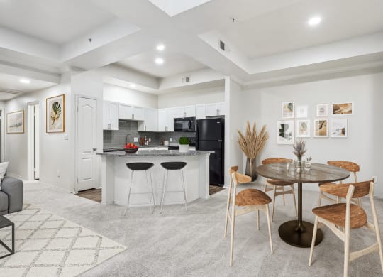 a living room with a kitchen and a dining table at La Ventura Apartments, Plano