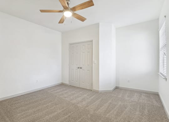 an empty living room with white walls and a ceiling fan at The Legends at Eagle Mountain Lake, Texas, 76179
