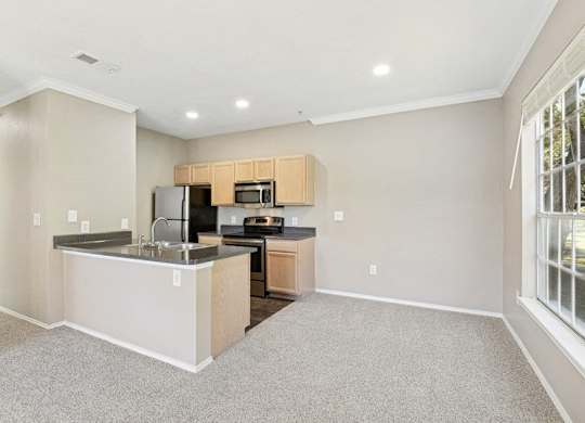 the living room and kitchen of a home with a large window