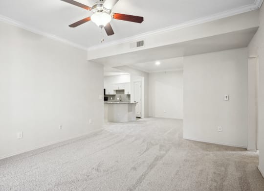 an empty living room with white walls and a ceiling fan at La Ventura Apartments, Plano, TX, 75093
