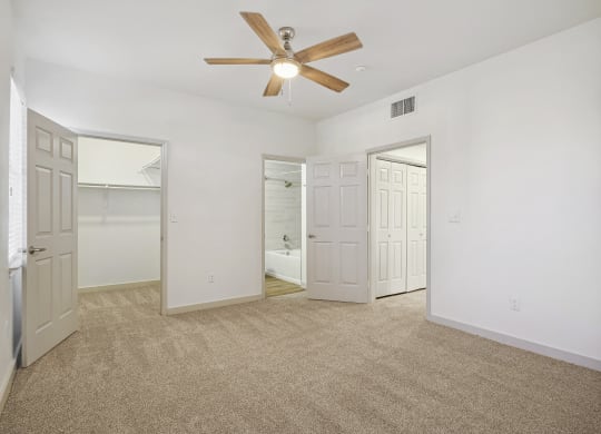 the living room of an empty apartment with white walls and a ceiling fan at The Legends at Eagle Mountain Lake, Fort Worth