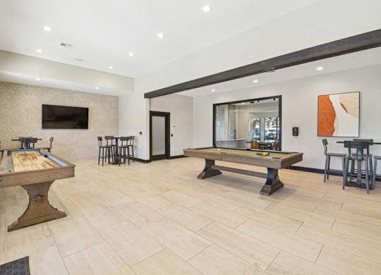the game room with two pool tables and a television