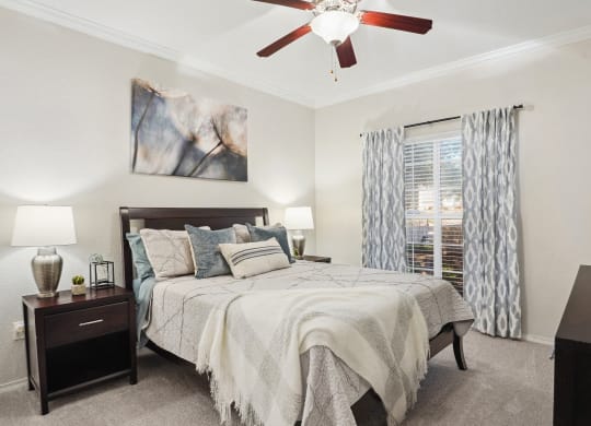 a bedroom with a large bed and a ceiling fan at La Ventura Apartments, Texas, 75093
