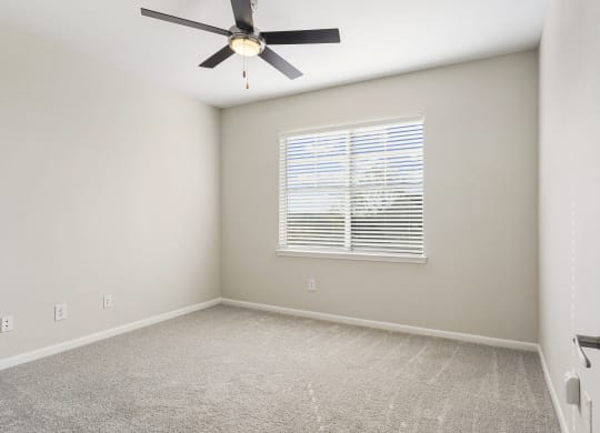 an empty room with a ceiling fan and a window at The Legends at Eagle Mountain Lake, Fort Worth, Texas