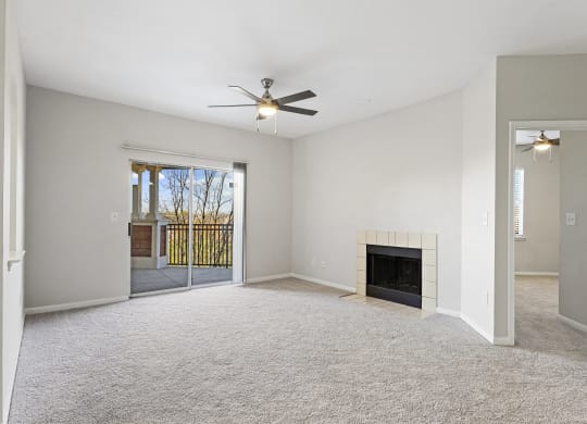 an empty living room with a fireplace and a ceiling fan at The Legends at Eagle Mountain Lake, Fort Worth