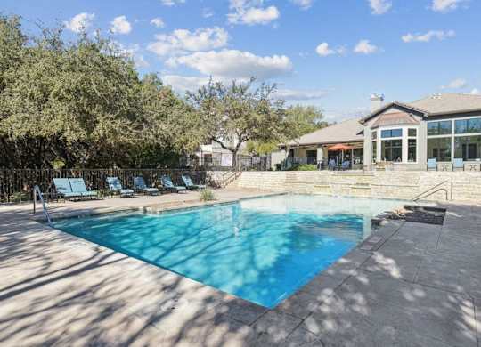 a swimming pool with a house in the background