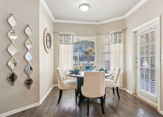 a dining room with a table and chairs and a window