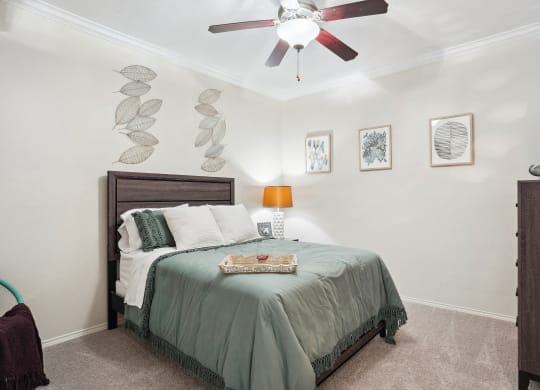 a bedroom with a bed and a ceiling fan at La Ventura Apartments, Texas, 75093