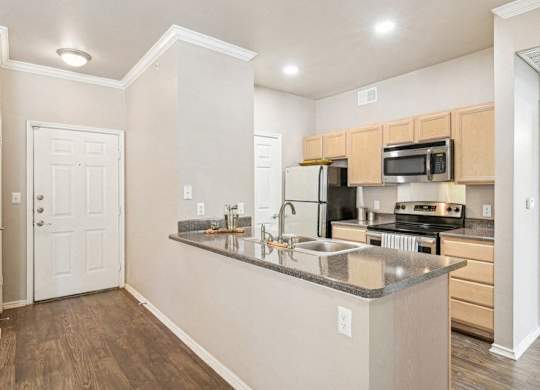 an empty kitchen with a counter top and a sink