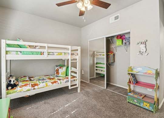 a bedroom with bunk beds and a ceiling fan