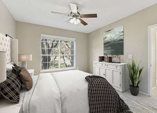 a bedroom with a large bed and a ceiling fan
