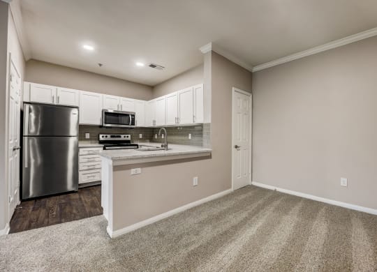 an empty kitchen with stainless steel appliances and white cabinets at Ventana Oaks Apartments, Austin, Texas
