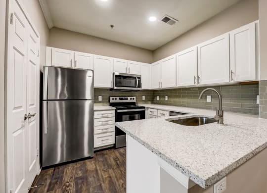 a kitchen with white cabinets and stainless steel appliances at Ventana Oaks Apartments, Austin, 78717