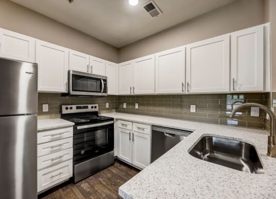 a kitchen with white cabinets and stainless steel appliances at Ventana Oaks Apartments, Austin