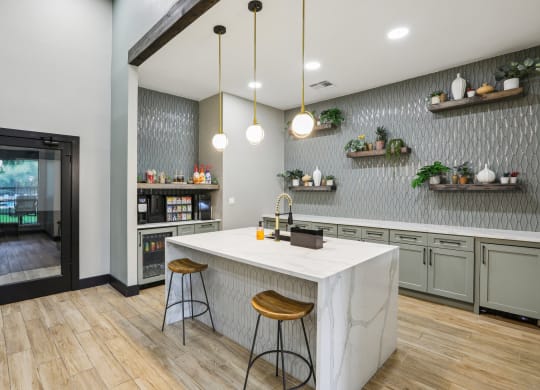 a kitchen with a marble counter top and two stools at Ventana Oaks Apartments, Austin, TX