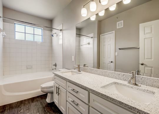 a bathroom with a sink and a toilet and a tub at Ventana Oaks Apartments, Austin