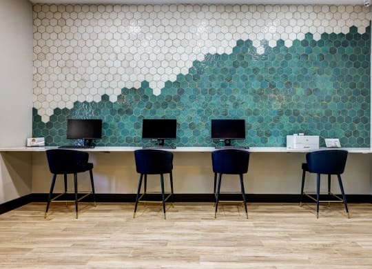 a row of desks with blue stools in front of a wall at Ventana Oaks Apartments, Austin, Texas