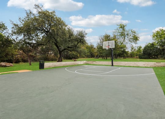 a basketball court in a park with trees at Ventana Oaks Apartments, Texas, 78717