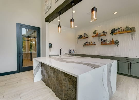 the kitchen has a large island with a marble counter top