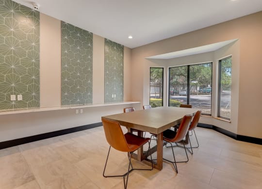a dining room with a table and chairs and large windows