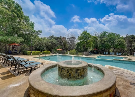 a swimming pool with a fountain in the middle