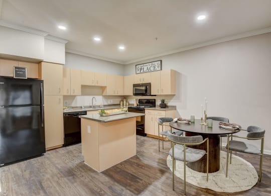 a kitchen with an island and a dining table with chairs at Artisan Apartments & Shops, Austin, 78729
