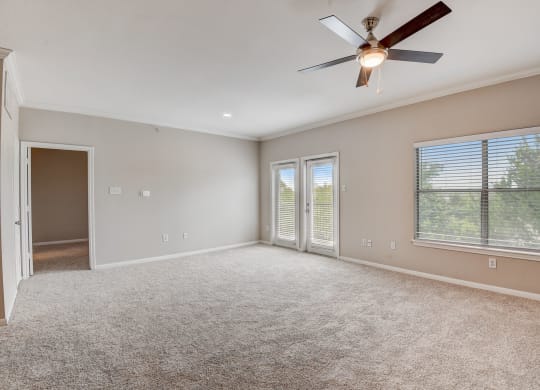 an empty living room with a ceiling fan and a window at Artisan Apartments & Shops, Austin
