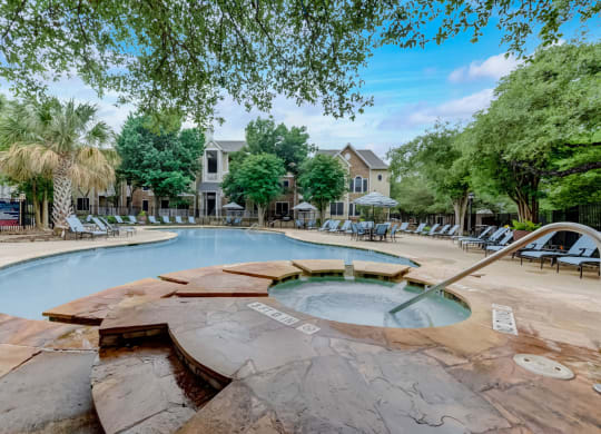 a swimming pool with chairs and trees and a resort style pool