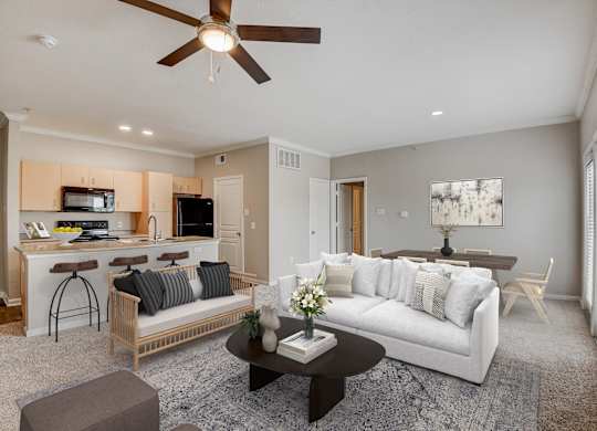A living room with a white couch and a ceiling fan at Artisan Apartments & Shops, Austin, TX 78729
