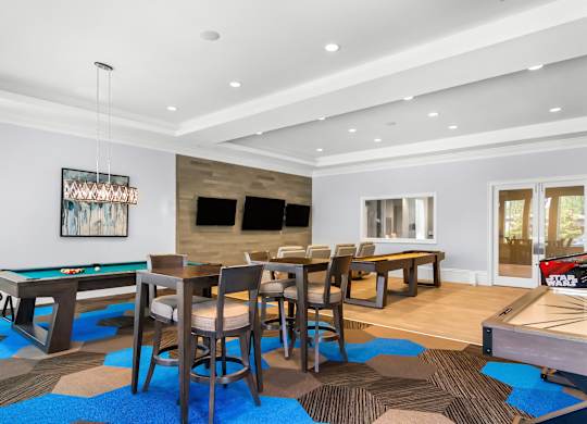 A room with a pool table and a dining table.