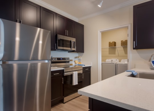 a kitchen with dark cabinets and white countertops  at The Oasis at Manatee River, Bradenton, FL, 34211