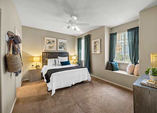 A bedroom with a large bed and a ceiling fan.
