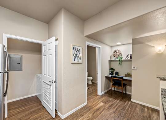 A kitchen with a refrigerator, a table, and a chair.