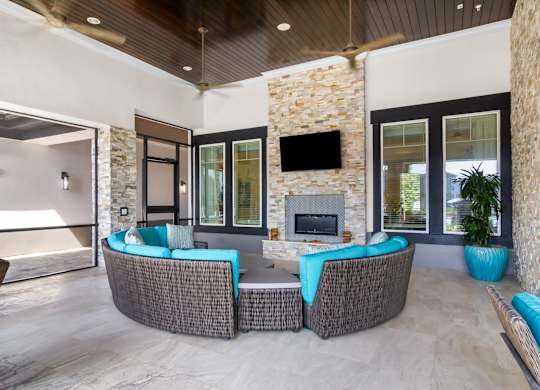 A modern living room with a stone fireplace and a television.