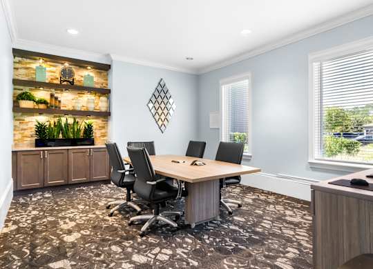 A conference room with a long table and chairs.
