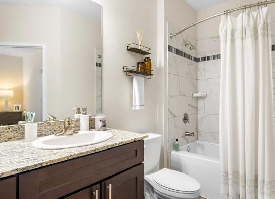 A bathroom with a marble countertop and a white toilet.