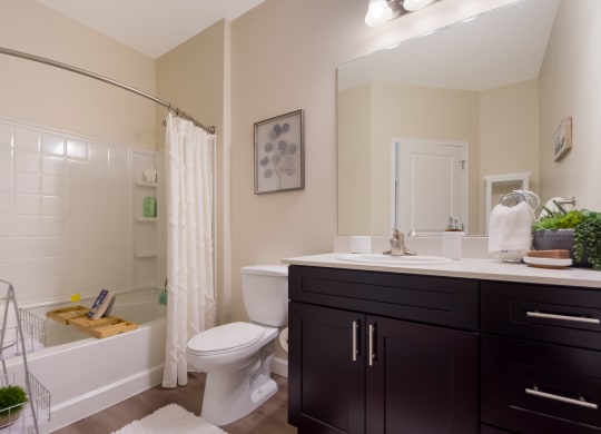 a bathroom with a white toilet next to a bathtub with a shower curtain  at The Oasis at Manatee River, Bradenton
