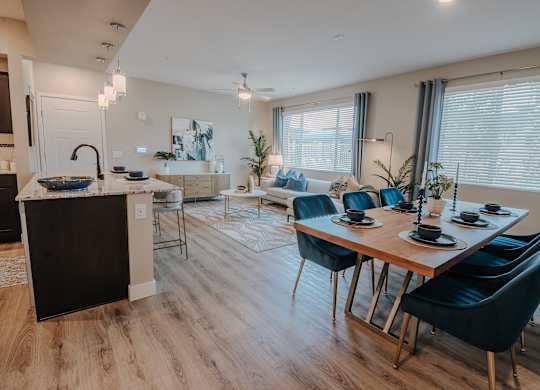 A modern kitchen with a dining table set at Level 25 at The Curve by Picerne, Las Vegas