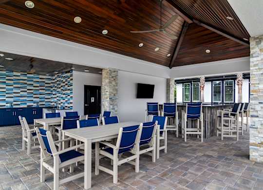A dining room with a stone wall and a wooden ceiling.