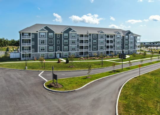 a large apartment building with a road in front of it at The Oasis at Plymouth, Massachusetts, 02360