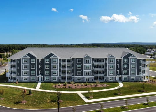 an aerial view of an apartment building with gray and black exterior at The Oasis at Plymouth, Massachusetts