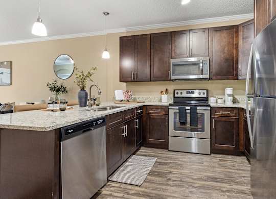 A modern kitchen with stainless steel appliances and wooden cabinets.