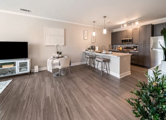 an open kitchen and living room with a dining area and a large tv at The Oasis at Plymouth, Massachusetts