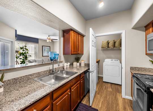 A kitchen with a sink, refrigerator, and oven.