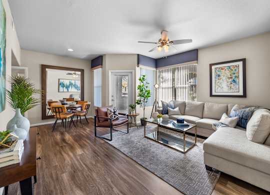 A living room with a white couch and a glass coffee table.