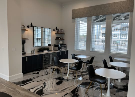a common area with tables and chairs and a counter with a microwave and coffee maker at Plymouth, Plymouth, 02360