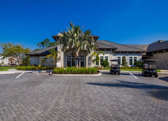 a large house with a driveway and palm trees in front of it  at The Oasis at Manatee River, Bradenton, FL, 34211